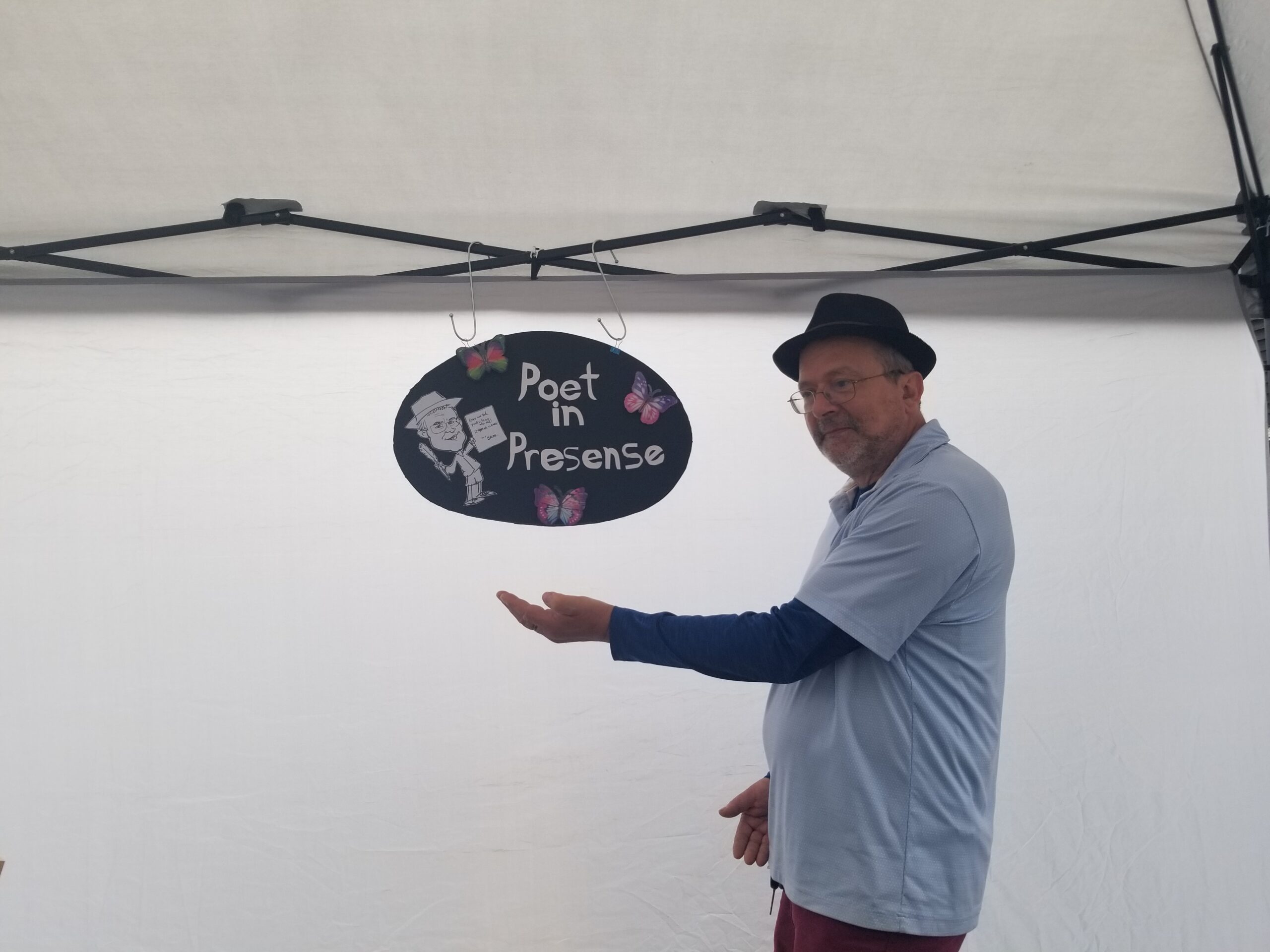 Ken Westdorp beside the Poet in Presence sign at Cloverdale Market Days